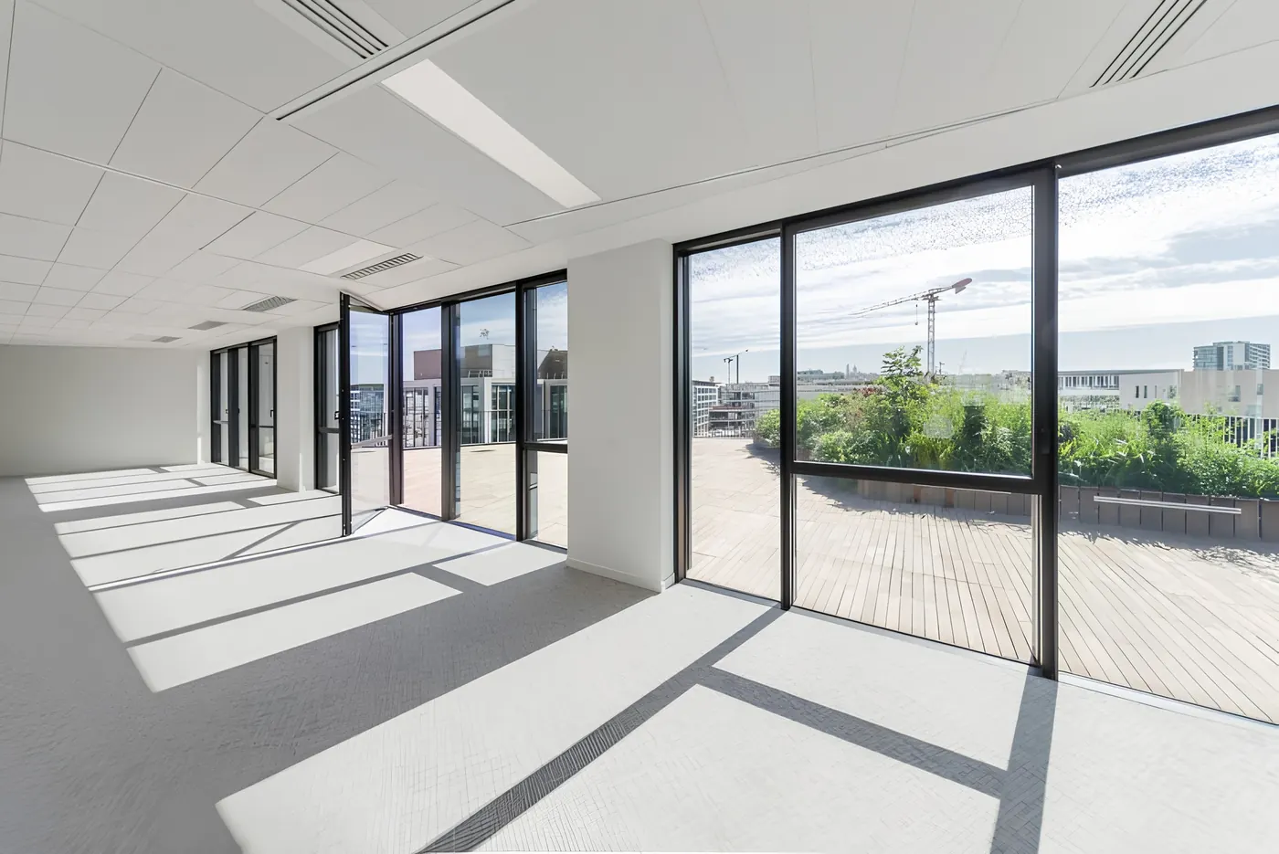 Plateau de bureaux ouvert sur une terrasse par de grandes menuiseries aluminium